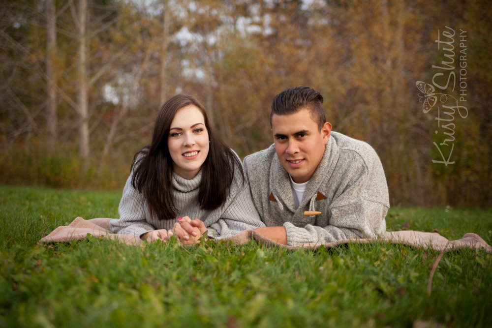 Kristy Shute Photography Engagement Huron Natural Area laying on the grass